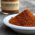 Pile of All American Rub on a white dish with spice jar in background