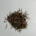 over head view of a loose pile of golden needles loose leaf tea
