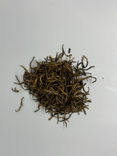 over head view of a loose pile of golden needles loose leaf tea